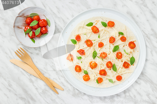 Image of Preparing a tortilla with tomatoes, cheese and basil