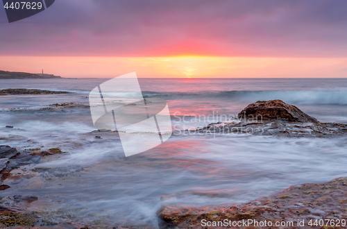 Image of Sunrise over the ocean and rocky reeef