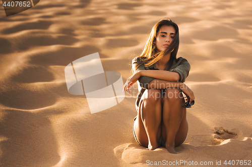 Image of Young girl sitting on a sand dune