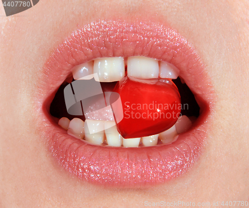 Image of red lollipop in mouth 
