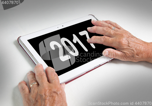 Image of Senior lady relaxing and her tablet - 2017