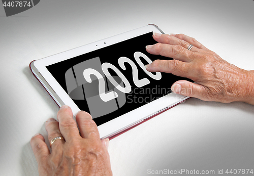 Image of Senior lady relaxing and her tablet - 2020