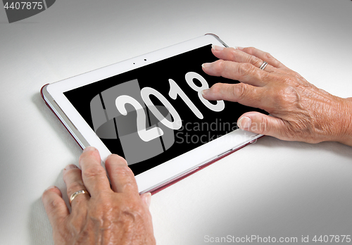 Image of Senior lady relaxing and her tablet - 2018