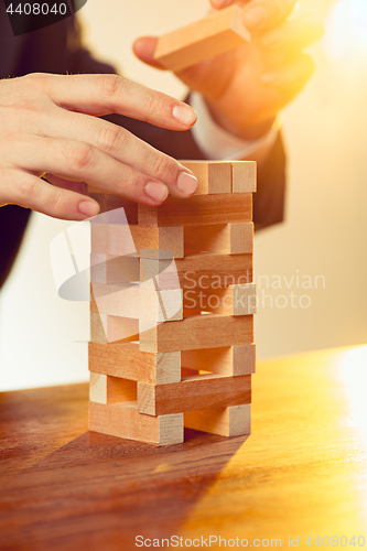 Image of Man and wooden cubes on table. Management concept