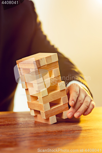 Image of Man and wooden cubes on table. Management concept