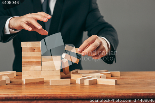 Image of Man and wooden cubes on table. Management concept