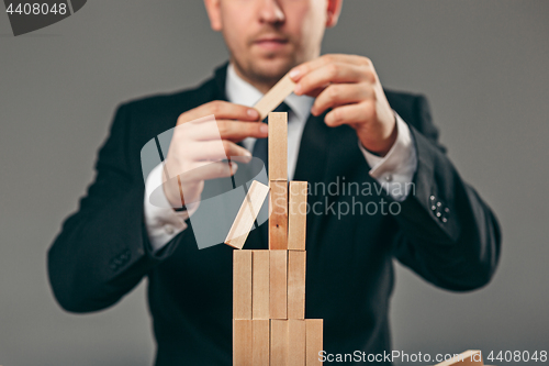 Image of Man and wooden cubes on table. Management concept