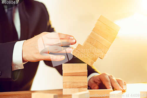 Image of Man and wooden cubes on table. Management concept