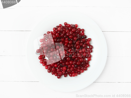 Image of bowl of cowberries on old wooden table