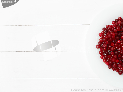 Image of bowl of cowberries on old wooden table