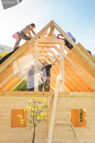 Image of Builders at work with wooden roof construction.