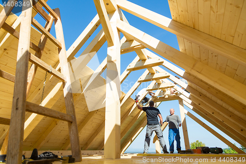 Image of Builders at work with wooden roof construction.