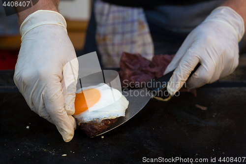 Image of Chef making beef burgers outdoor on open kitchen international food festival event.