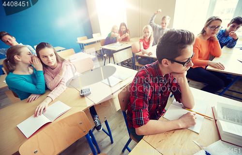 Image of students gossiping behind classmate back at school