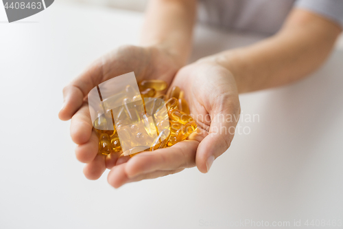 Image of hands holding cod liver oil capsules