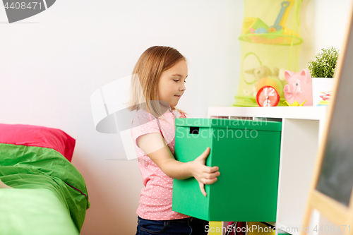 Image of happy little girl with toy box at home