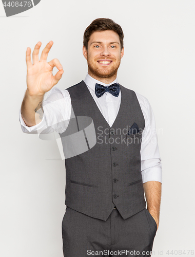 Image of happy man in festive suit showing ok hand sign