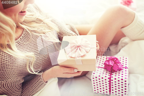 Image of close up of woman with birthday gifts in bed