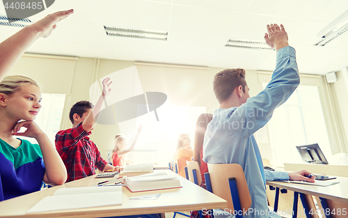 Image of group of students with raised hands at high school