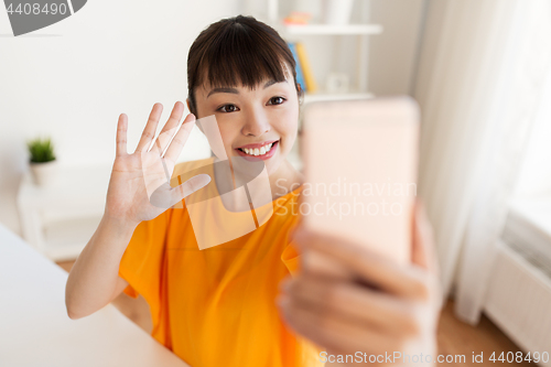 Image of happy asian woman taking selfie by smartphone