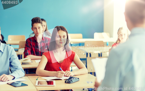 Image of group of students and teacher with papers or tests