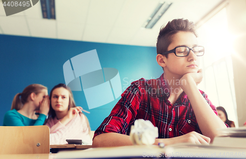 Image of students gossiping behind classmate back at school