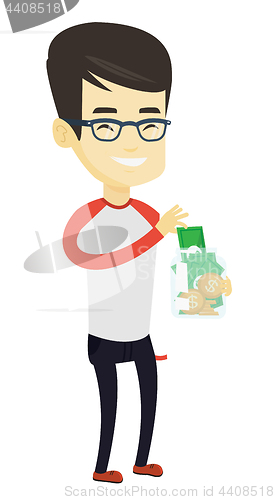 Image of Man putting dollar money into glass jar.