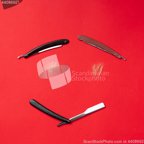 Image of combs and hairdresser tools on red background top view