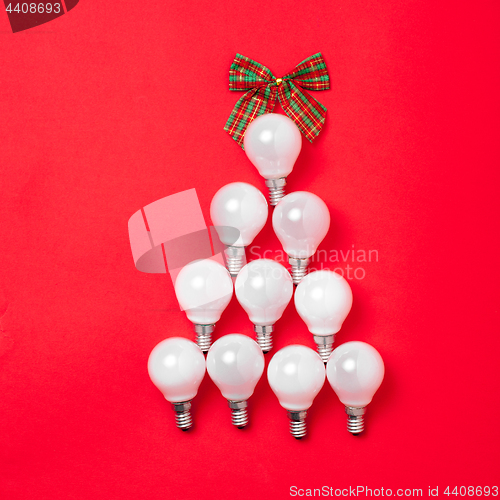 Image of The christmas tree from lantern lamps laying on red background with copy space.