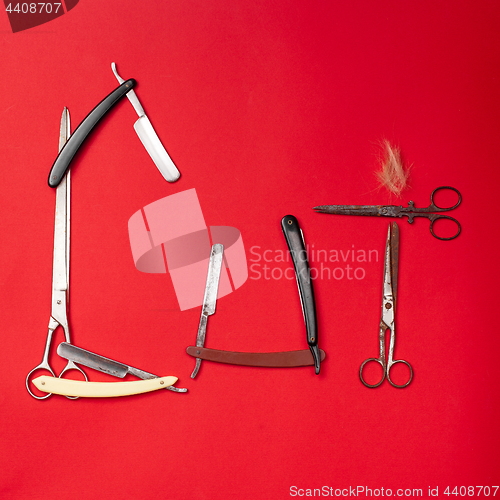 Image of combs and hairdresser tools on red background top view