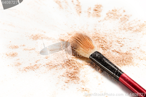 Image of Close-up of crushed mineral shimmer powder golden color with makeup brush