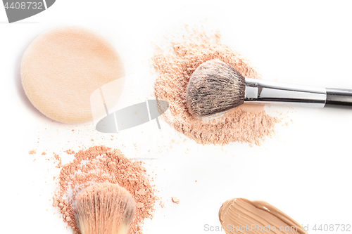 Image of Close-up of crushed mineral shimmer powder golden color with makeup brush
