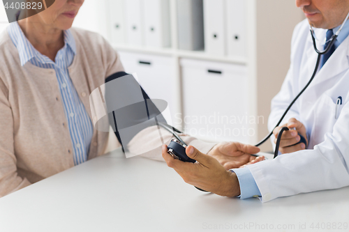 Image of doctor with tonometer and senior woman at hospital