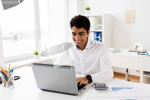 Image of businessman with laptop and papers at office