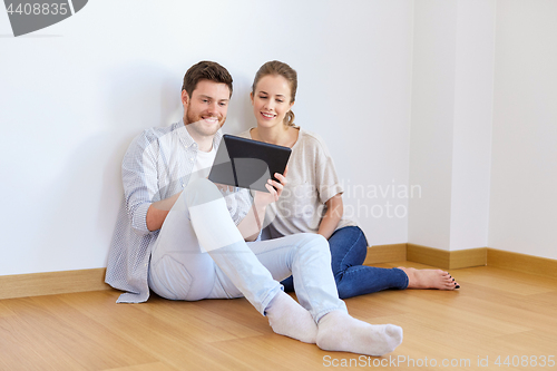 Image of happy couple with tablet pc computer at new home