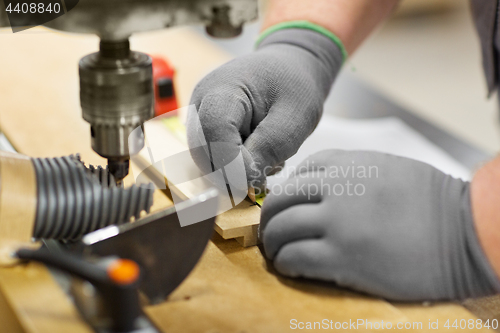 Image of carpenter with ruler measuring board at workshop