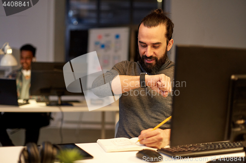 Image of man with smartwatch using voice recorder at office