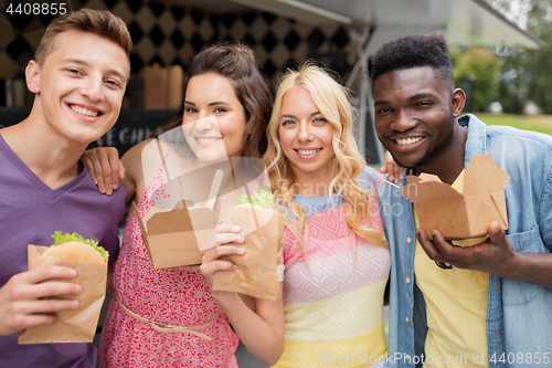 Image of happy friends with wok and burger at food truck