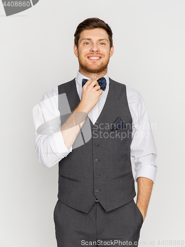 Image of happy man in festive suit dressing for party