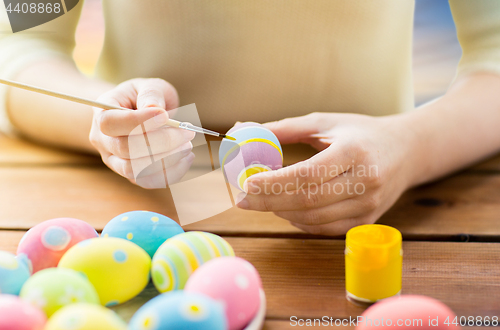 Image of close up of woman hands coloring easter eggs