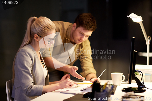 Image of business team with papers working at night office