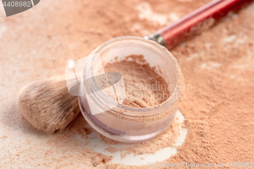 Image of Close-up of crushed mineral shimmer powder golden color with makeup brush