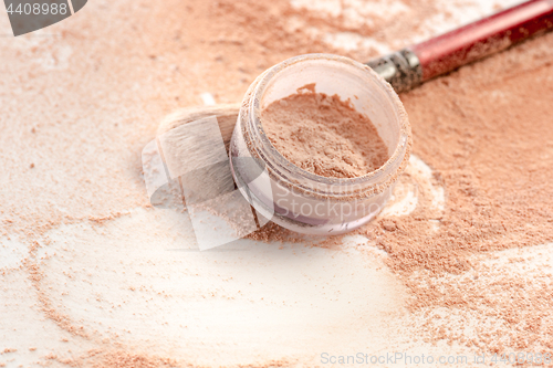 Image of Close-up of crushed mineral shimmer powder golden color with makeup brush