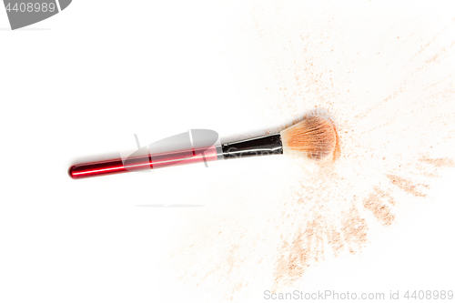 Image of Close-up of crushed mineral shimmer powder golden color with makeup brush