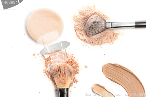 Image of Close-up of crushed mineral shimmer powder golden color with makeup brush