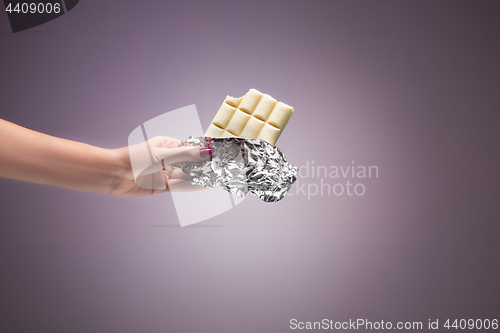 Image of Hands of a woman holding a tile of chocolate