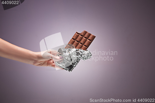 Image of Hands of a woman holding a tile of chocolate