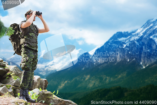 Image of soldier with backpack looking to binocular