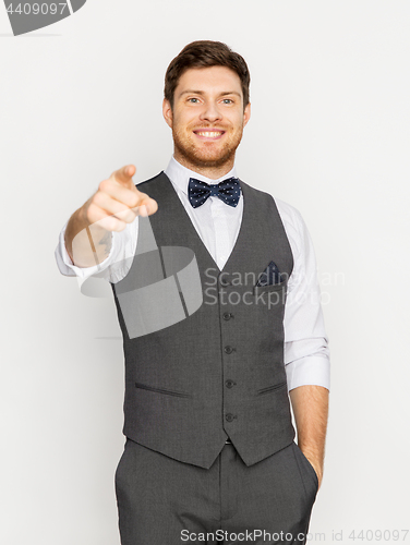 Image of happy man in festive suit pointing finger at you