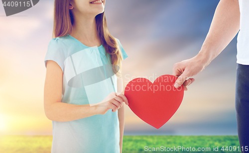 Image of close up of daughter and father holding red heart